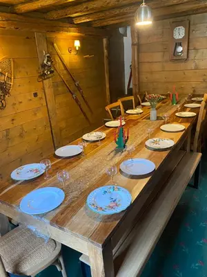 a long wooden table with plates and wine glasses at Joyeux Flocon - Spacieux chalet in Les Contamines-Montjoie