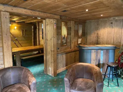 two leather chairs in a room with a bar at Joyeux Flocon - Spacieux chalet in Les Contamines-Montjoie