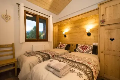 a bedroom with two beds and a window at Samoëns, new apartment, 3 bedrooms, 6 persons, close to village centre and skibus in Samoëns