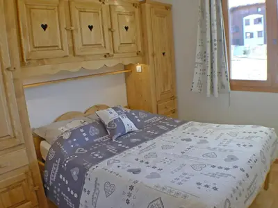 a bedroom with a bed and a wooden cabinet at 3 pièces avec terrasse, animaux admis, parking – Samoëns - FR-1-629-137 in Samoëns