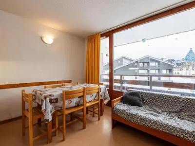 a dining room with a table and a large window at Les Eterlous 25 - Appt vue pistes 4 pers in Morillon