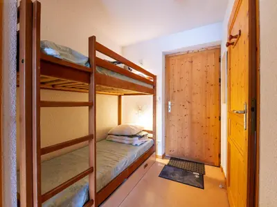 a bedroom with two bunk beds and a door at Les Eterlous 25 - Appt vue pistes 4 pers in Morillon