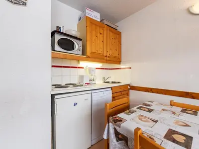 a small kitchen with a table and a microwave at Les Eterlous 25 - Appt vue pistes 4 pers in Morillon