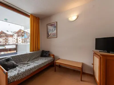 a living room with a couch and a large window at Les Eterlous 25 - Appt vue pistes 4 pers in Morillon