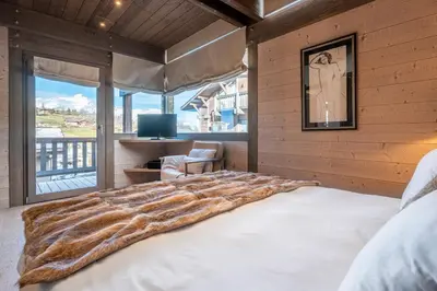 a log cabin with a view of a snow covered mountain at Chalet Satine - Luxe au pied des pistes in Demi-Quartier