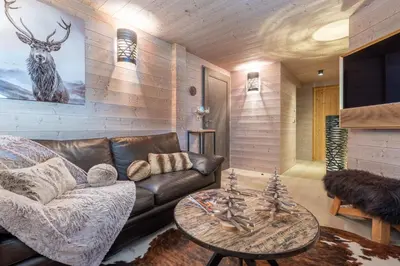a bedroom with a large bed with a wooden wall at Chalet Satine - Luxe au pied des pistes in Demi-Quartier