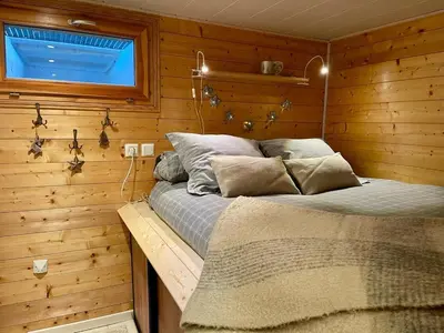 a bedroom with a bed in a wooden wall at Cosy Petite Chalet T3, Jardin, Terrasse, Parking. Chamonix Mont-blanc. in Les Houches