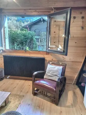 a chair sitting in a room with a window at Cosy Petite Chalet T3, Jardin, Terrasse, Parking. Chamonix Mont-blanc. in Les Houches