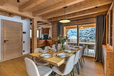 a dining room with a wooden table and chairs at Chalet Belle des Neiges - Alpes Travel - Sleeps 9 in Les Houches