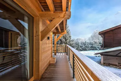 a wooden walkway to a cabin in the snow at Chalet Belle des Neiges - Alpes Travel - Sleeps 9 in Les Houches