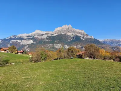 a green field with a mountain in the background at Les Balcons du Mont-Blanc : Appartement centre village in Cordon
