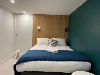 a bedroom with a large bed with a blue wall at Flaine Forum G1 Cassiopée Mezzanine & Terrasse in Flaine