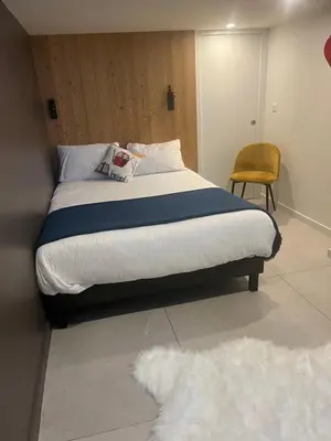 a bedroom with a bed and a chair and a rug at Flaine Forum G1 Cassiopée Mezzanine & Terrasse in Flaine