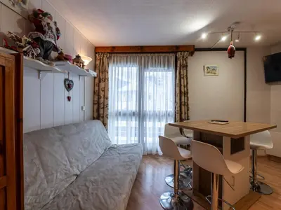 a bedroom with a bed and a table and chairs at Praz des Esserts - 43 - Appt pied pistes - 6 pers in Morillon