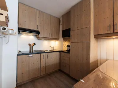 a kitchen with wooden cabinets and a sink at Les Sitelles - 12 - Appt vue montagne - 6 pers in Morillon