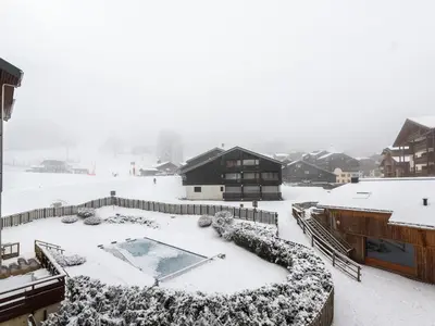 a snow covered backyard with a swimming pool and a house at Les Sitelles - 12 - Appt vue montagne - 6 pers in Morillon