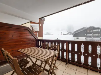 a wooden table and chairs on a balcony at Les Sitelles - 12 - Appt vue montagne - 6 pers in Morillon
