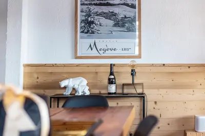 a table with a bottle of wine and a bear statue at Appartement Solaris - Magnificent views and great exposure! in Megève