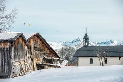 an old barn in the snow with a church at Appartement Solaris - Magnificent views and great exposure! in Megève