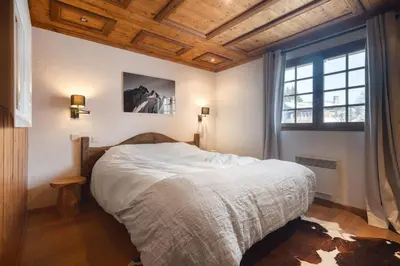 a bedroom with a bed and a large window at Appartement Solaris - Magnificent views and great exposure! in Megève