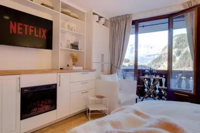 a bedroom with a bed and a tv and a fireplace at Luxury Studio - Mountain View & 100m to Slopes - Near Chamonix in Les Houches