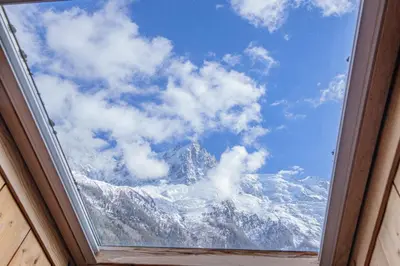a view of a snow covered mountain through a window at Apartment Capucin - A 3 Bedroom Chamonix Mountain Loft in Chamonix-Mont-Blanc