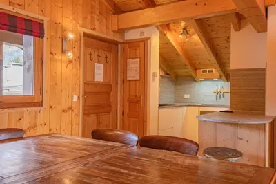 a dining room with a large wooden table and chairs at Apartment Capucin - A 3 Bedroom Chamonix Mountain Loft in Chamonix-Mont-Blanc