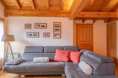 a living room with a gray couch and wooden ceilings at Apartment Capucin - A 3 Bedroom Chamonix Mountain Loft in Chamonix-Mont-Blanc