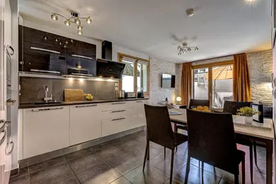 a kitchen with white cabinets and a table with chairs at Aiguille 1 in Chamonix-Mont-Blanc