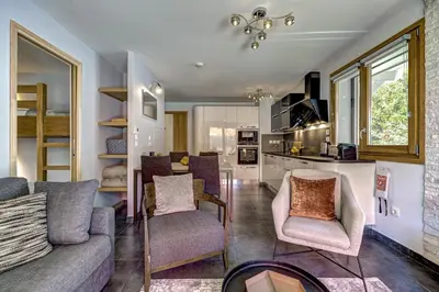 a living room with a couch and chairs and a kitchen at Aiguille 1 in Chamonix-Mont-Blanc
