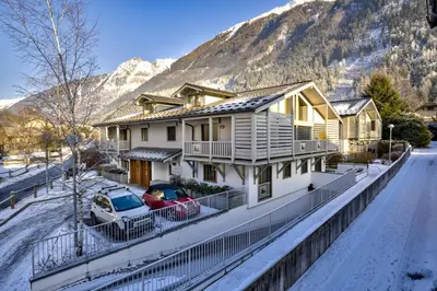a house in the snow with mountains in the background at Aiguille 1 in Chamonix-Mont-Blanc