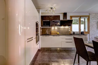 a kitchen with white cabinets and a table and chairs at Aiguille 1 in Chamonix-Mont-Blanc