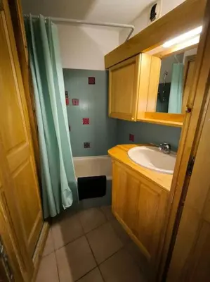a bathroom with a sink and a shower curtain at Appartement à 50m des remontées in Saint-Gervais-les-Bains
