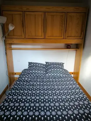 a bed with two blue pillows in a room at Appartement à 50m des remontées in Saint-Gervais-les-Bains