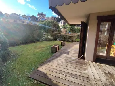 a wooden walkway leading to a house with a yard at Appartement à 50m des remontées in Saint-Gervais-les-Bains