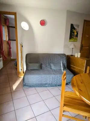 a living room with a couch and a table at Appartement à 50m des remontées in Saint-Gervais-les-Bains