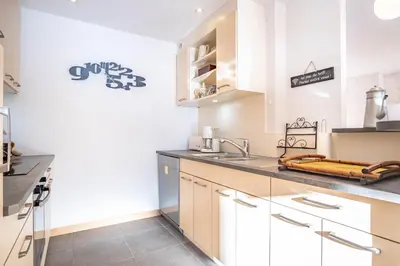 a kitchen with white cabinets and a sink at Le Savoy 2 - Pied des pistes - Centre in Chamonix-Mont-Blanc
