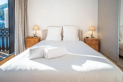 a bedroom with a large white bed with two lamps at Le Savoy 2 - Pied des pistes - Centre in Chamonix-Mont-Blanc