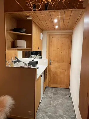 a kitchen with a sink and a wooden door at un nid avec balcon in Saint-Gervais-les-Bains