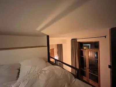 a bedroom with a white bed and a window at un nid avec balcon in Saint-Gervais-les-Bains