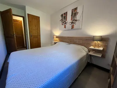 a bedroom with a large white bed in a room at Appartement rénové avec piscine à Samoëns - FR-1-624-151 in Samoëns