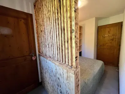 a bedroom with a bed and a wooden door at Appartement rénové avec piscine à Samoëns - FR-1-624-151 in Samoëns