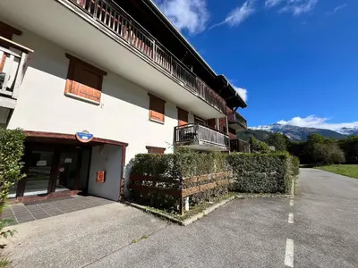 a building with a parking lot in front of it at Appartement rénové avec piscine à Samoëns - FR-1-624-151 in Samoëns