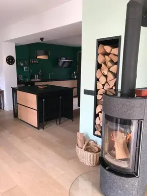 a living room with a fireplace with a pile of logs at Maison Sallanches 12 couchages in Sallanches