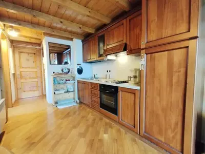 a kitchen with wooden cabinets and a wooden floor at Résidence Aigle Royal - L'Aigle Royal MAE-7671 in Les Houches