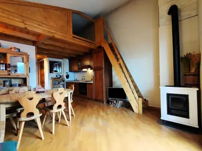 a kitchen with a table and a staircase in a room at Résidence Aigle Royal - L'Aigle Royal MAE-7671 in Les Houches
