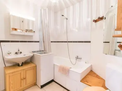 a white bathroom with a sink and a shower at Appartement cœur de village in Samoëns