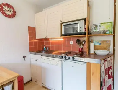 a kitchen with a stove and a microwave at Appartement cœur de village in Samoëns