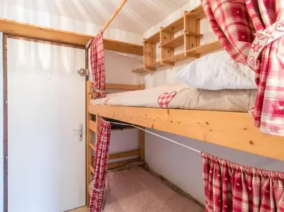 a bedroom with a bunk bed in a tiny house at Appartement cœur de village in Samoëns