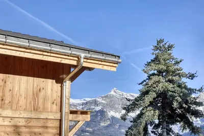 a building with a tree in front of a mountain at chalet Louis situé 25 km Chamonix in Saint-Gervais-les-Bains